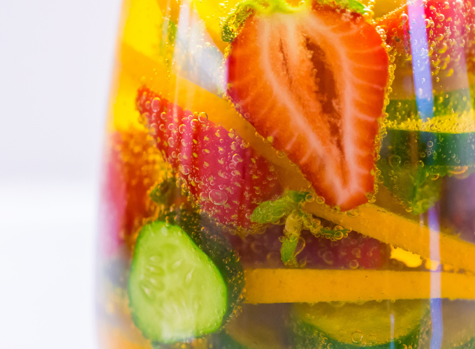 close up of pimms and lemonade with strawberries and cucumber slices